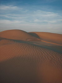 Scenic view of desert against cloudy sky