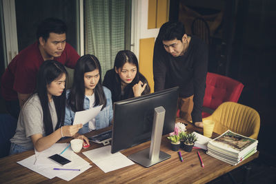 Business persons looking at computer at office