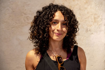 Portrait of a mixed race woman smiling while posing inside an abandoned factory.