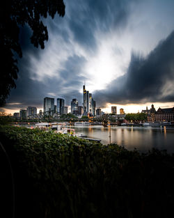 River by illuminated city against sky at dusk in frankfurt, germany 