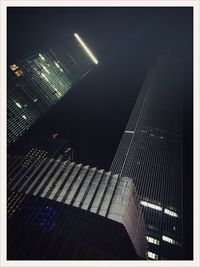 Low angle view of illuminated skyscraper against sky at night