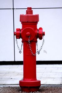 Close-up of red fire hydrant against wall