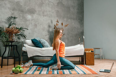 The athlete stretching , meditating, sitting on a floor in the bedroom