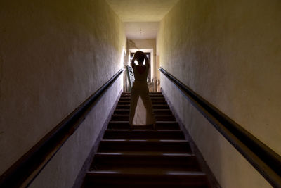 Rear view of man walking on staircase