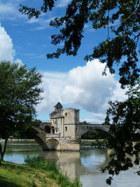 Historic building by river against sky