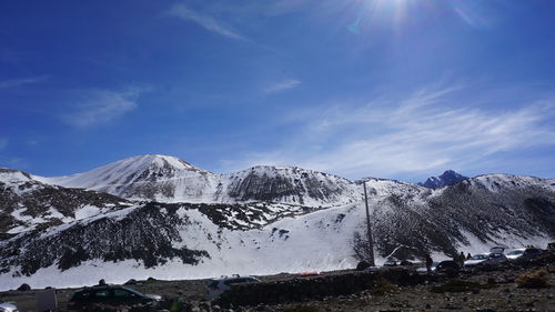 Scenic view of snowcapped mountains against blue sky