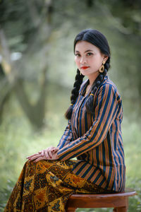 Young woman looking away while standing outdoors