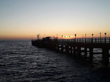 Beautiful sunset. black sea. sky. the sun. bridge. pier over sea against clear sky during sunset. so