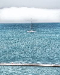 Sailboat sailing on sea against sky