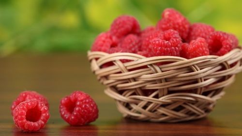 Close-up of raspberries in basket on table