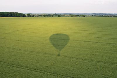 Heart shape on grassy field against sky