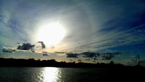 Sun shining through clouds over sea