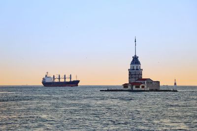 Ship in sea against clear sky during sunset