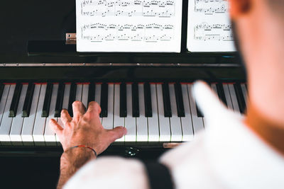 Midsection of man playing piano