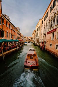 Typical venetian boat while sailing on characteristic tourist canal