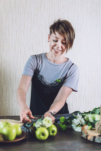 Woman standing with vegetables on table