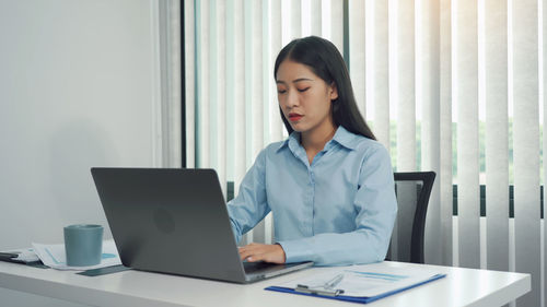 Businesswoman using laptop at office