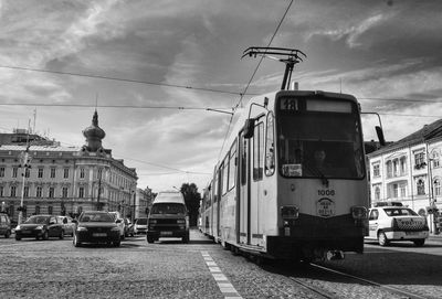 Cars on road against cloudy sky