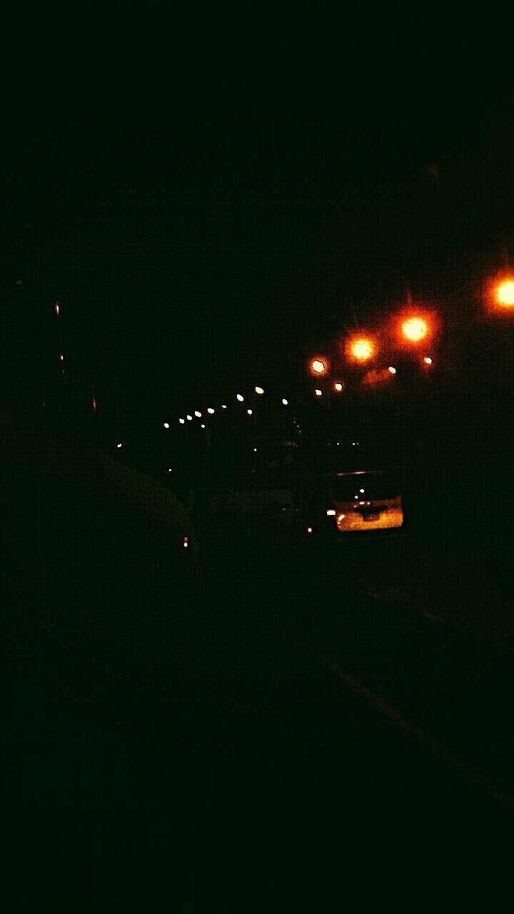 CARS ON ILLUMINATED BRIDGE AGAINST SKY AT NIGHT