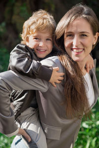 Portrait of smiling mother piggybacking son