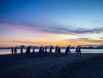 People exercising on sand at beach