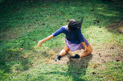 Rear view of woman dancing on grass