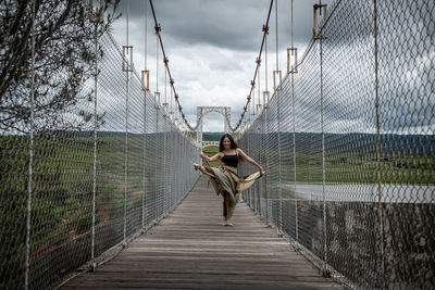 Full length of woman dancing on footbridge