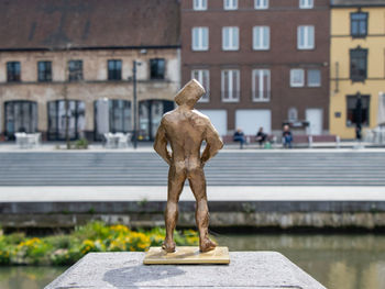 Statue standing in front of a canal