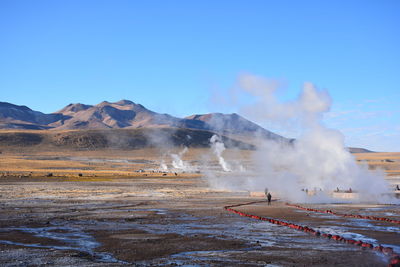 People at hot spring against mountain