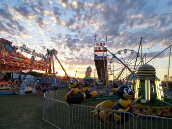 Rides at carnival against sky during sunset