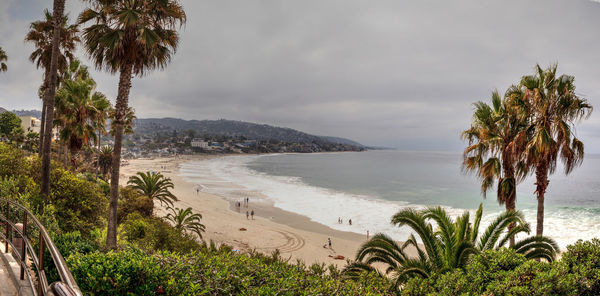 Scenic view of beach against cloudy sky