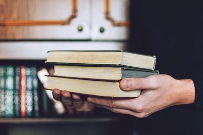 Midsection of man holding books