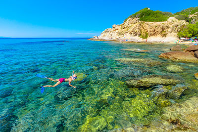 Man swimming in sea against sky