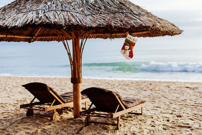 Close-up of chair on beach against sky