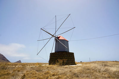 Traditional windmill on field against sky