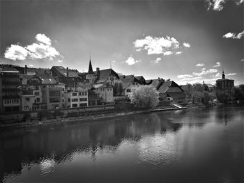 Reflection of houses in city against sky