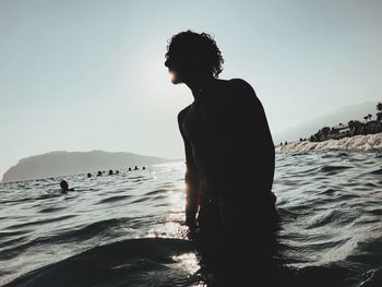 Silhouette man on beach against sky during sunset
