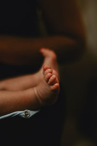 Low section of newborn baby lying on bed at home