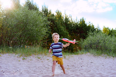 Caucasian little boy launching toy plane into the air