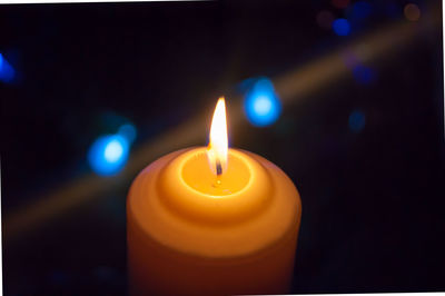 Close-up of lit candles in darkroom