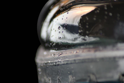 Close-up of wet glass against black background