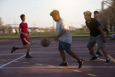 Teenager boys playing street basketball