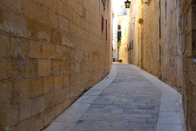 Narrow alley amidst buildings in ancient city of mdina