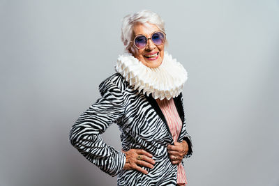 Portrait of young woman standing against white background