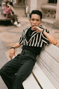 Side view of young man sitting on chair