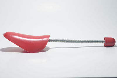 Close-up of red ball on table against white background