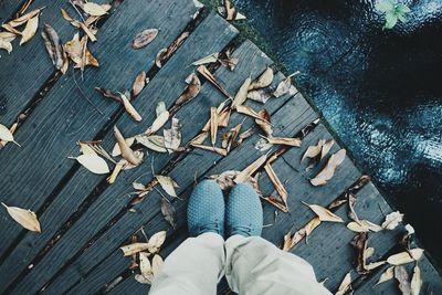 Low section of man standing on boardwalk