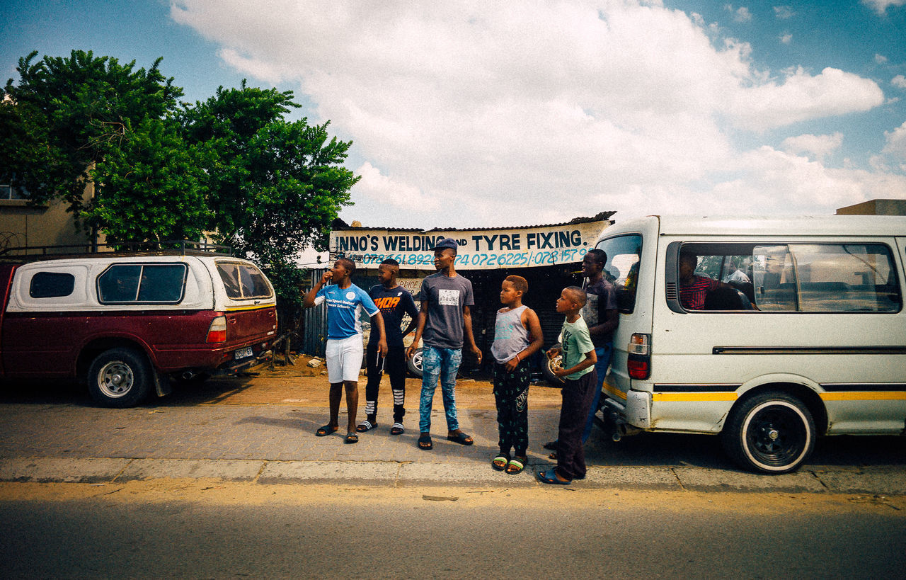 PEOPLE ON ROAD AGAINST SKY