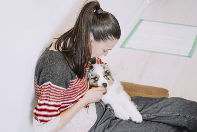 Side view of girl playing with dog