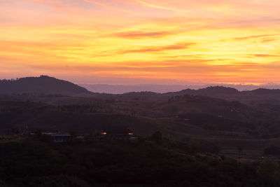 Scenic view of landscape against dramatic sky during sunset